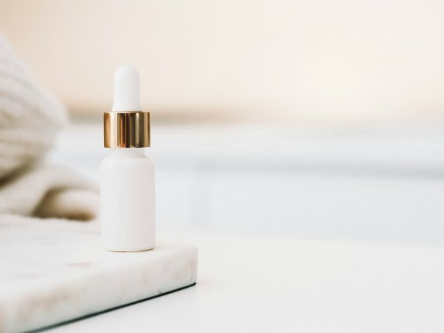 Skincare serum dropper in a light studio setting; illustrative stock photo