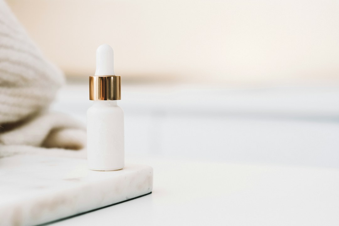 Skincare serum dropper in a light studio setting; illustrative stock photo